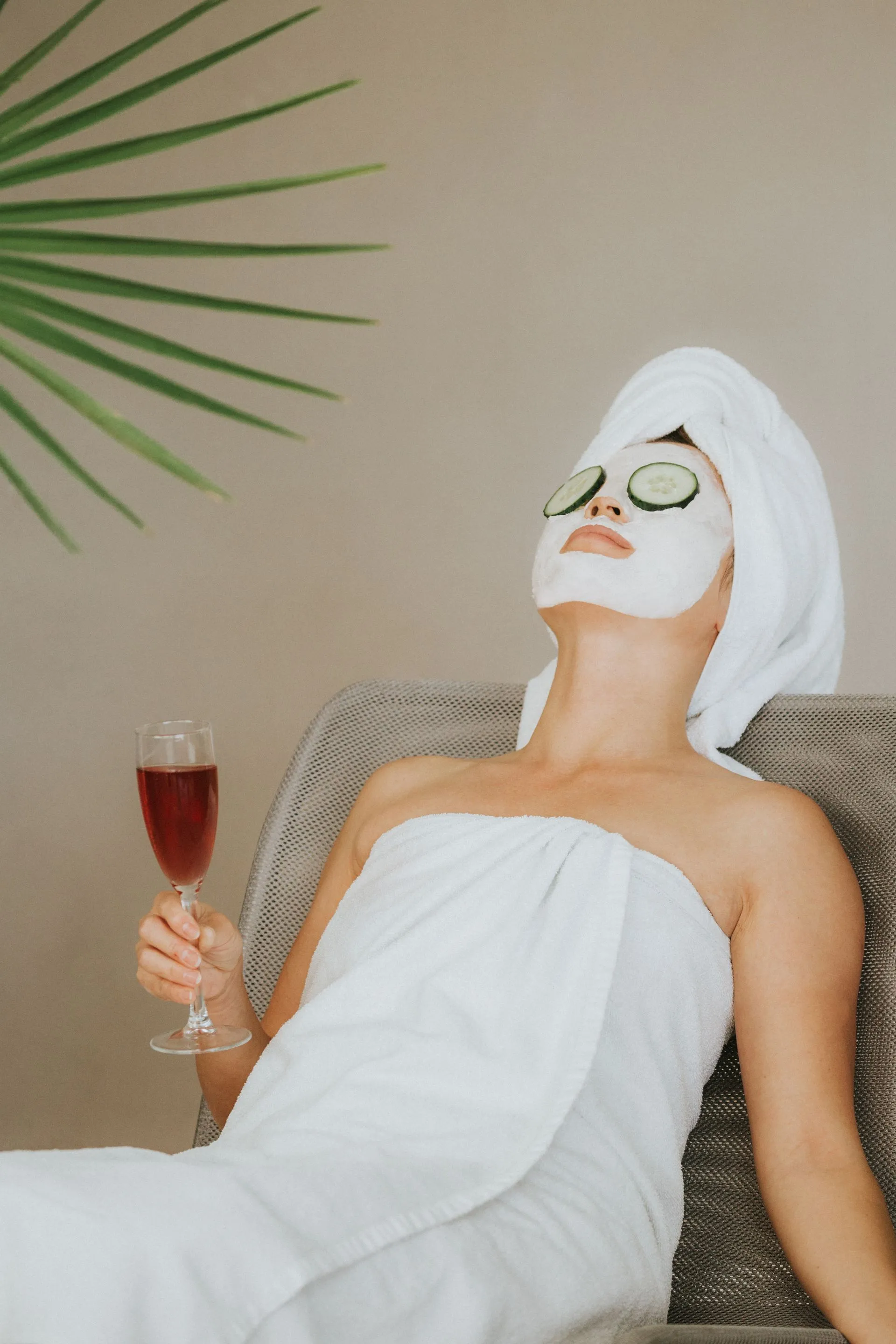 Woman enjoying a spa day with face mask and wine